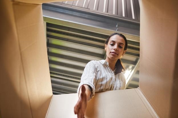 A woman reaching in a box in a self storage facility