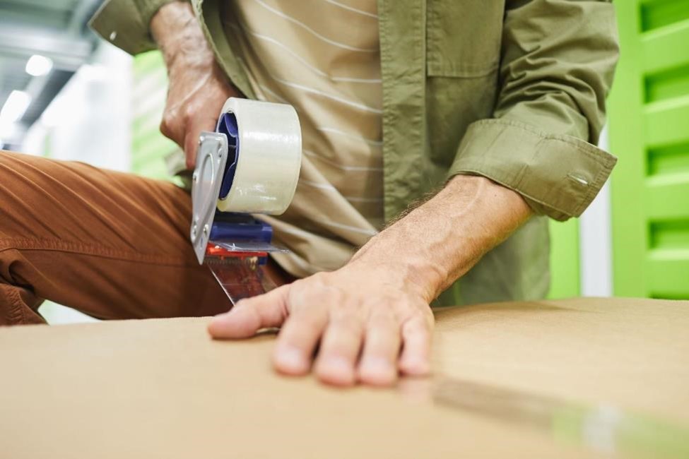 A man using tape on a box