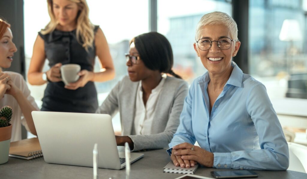 Professional business woman smiling with female associates.