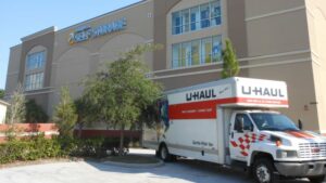 Uhaul truck parked in front of a Compass Self Storage facility.
