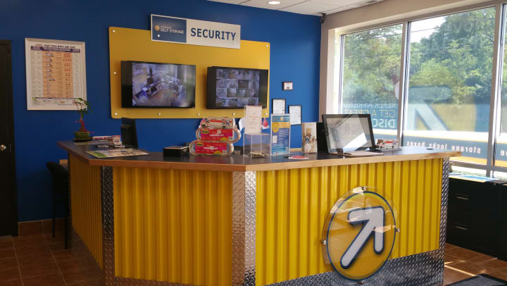 Compass Self Storage rental office with security monitors.