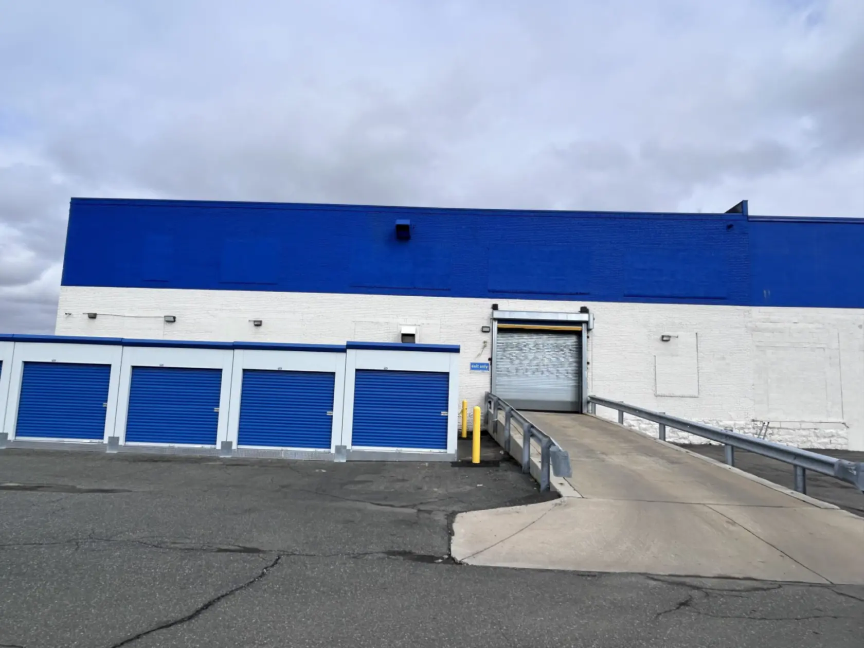 Blue and white storage facility with a drive-up ramp into building.