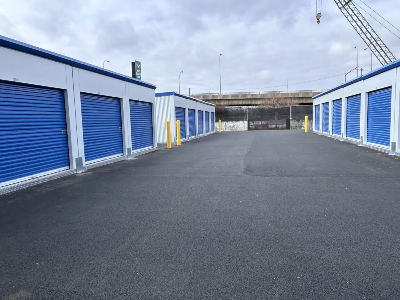 Paved, drive-up storage units with blue doors.