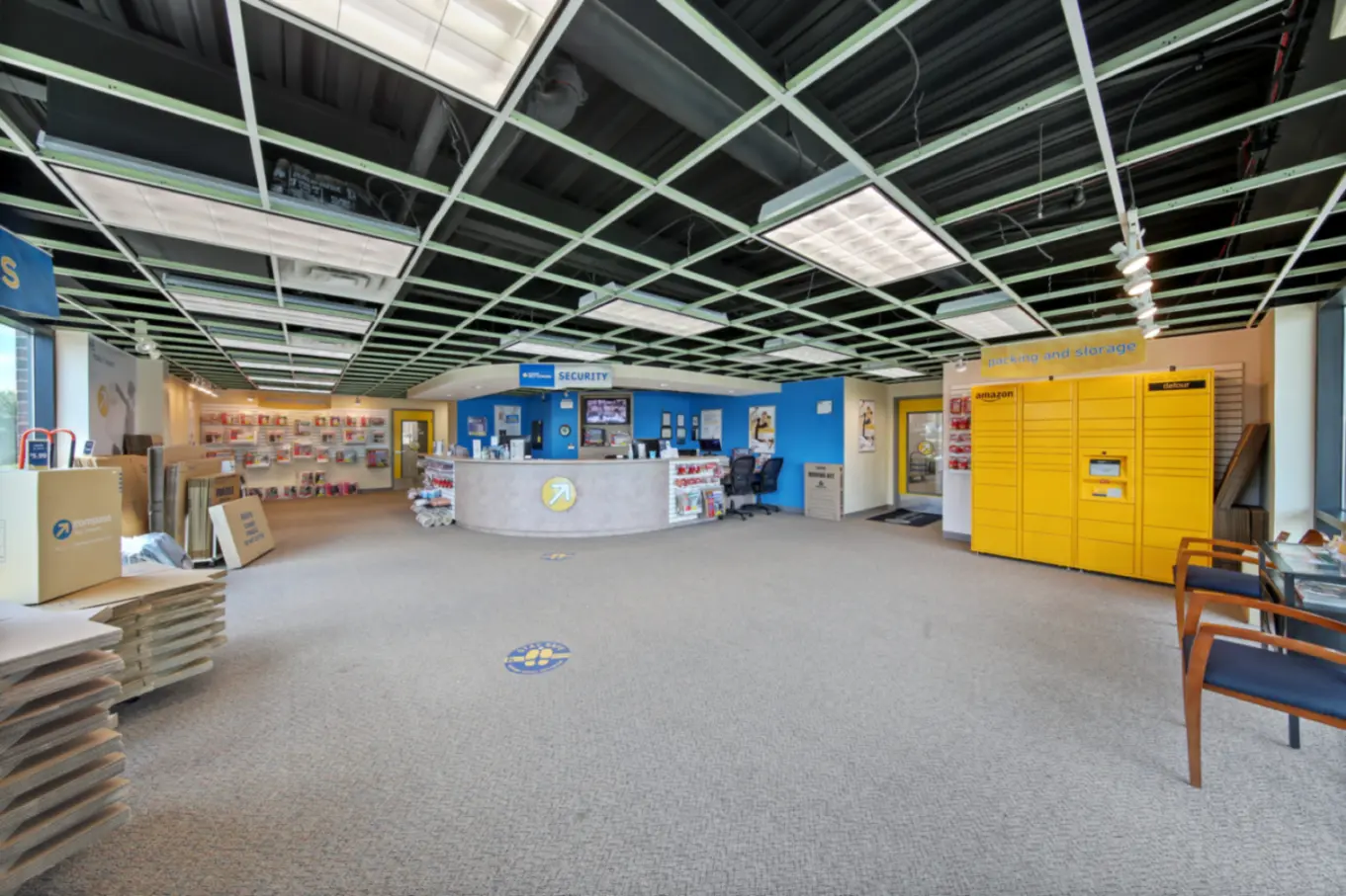 Large front office with an Amazon pickup box and storage supplies.