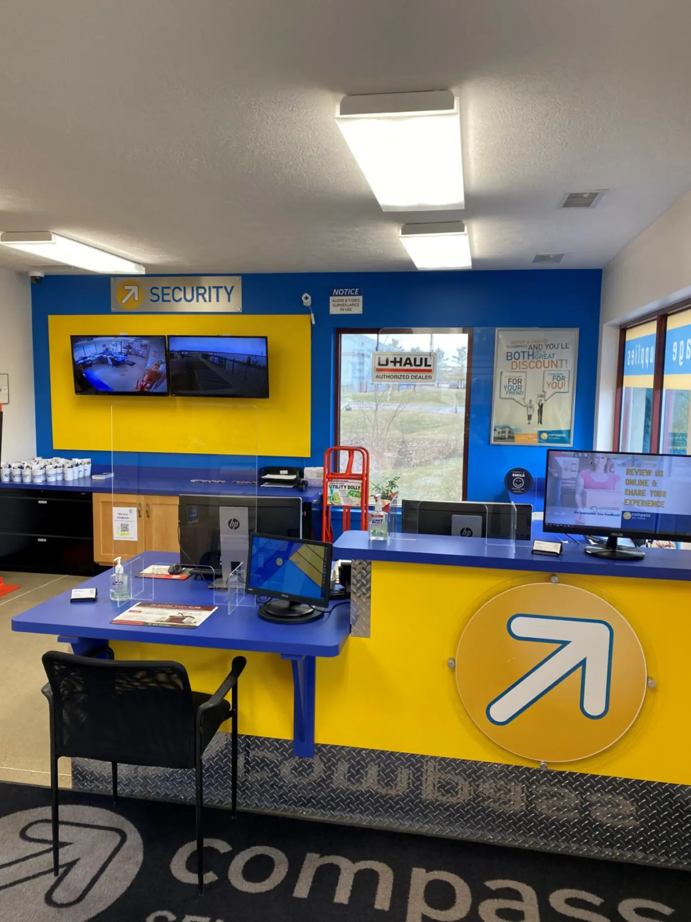 Compass Self Storage office with security camera footage in the back.