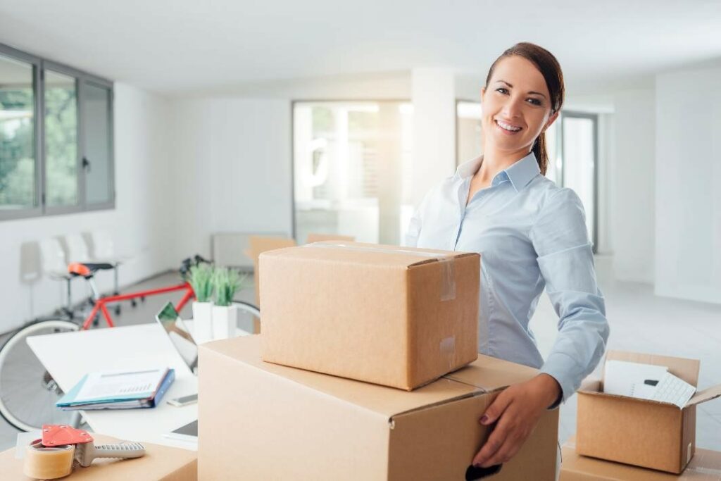 Smiling woman with moving boxes.