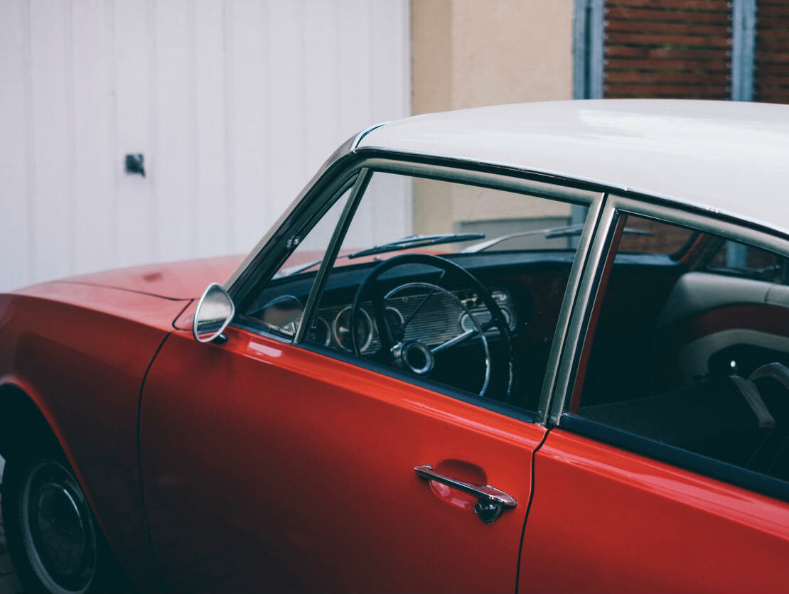 classic red car sitting outside on a driveway