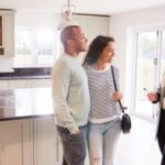 couple talking to a real estate agent in a kitchen