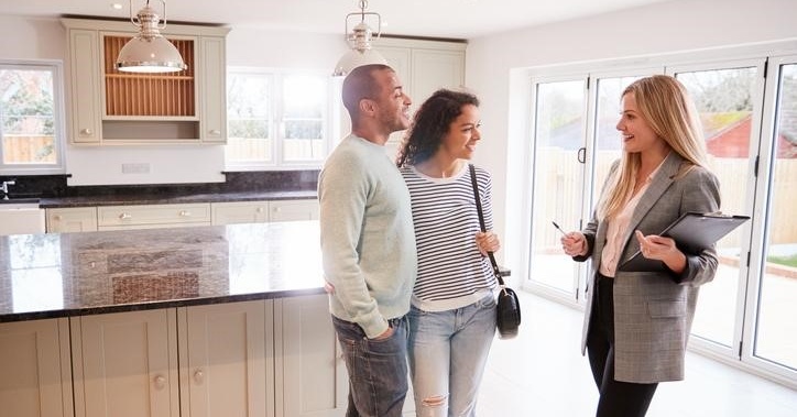 couple talking to a real estate agent in a kitchen