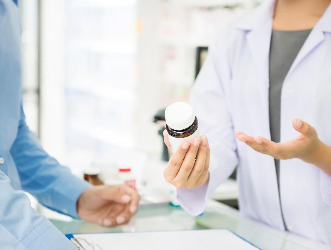 a sales rep is talking with a medical professional who's holding a bottle of medicine