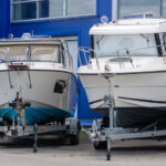 Two boats resting on trailers while in storage for the winter.