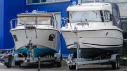 Two boats resting on trailers while in storage for the winter.
