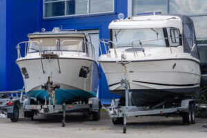 Two boats resting on trailers while in storage for the winter.