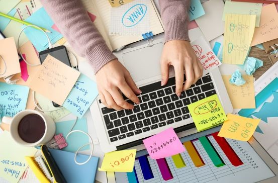 A laptop on top of a pile of post it notes