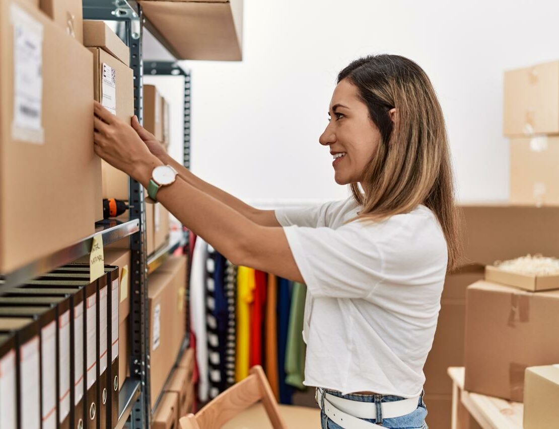 Woman placing a labeled box on shelving unit