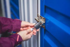 A woman opens a lock on a blue storage unit
