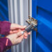 A woman opens a lock on a blue storage unit
