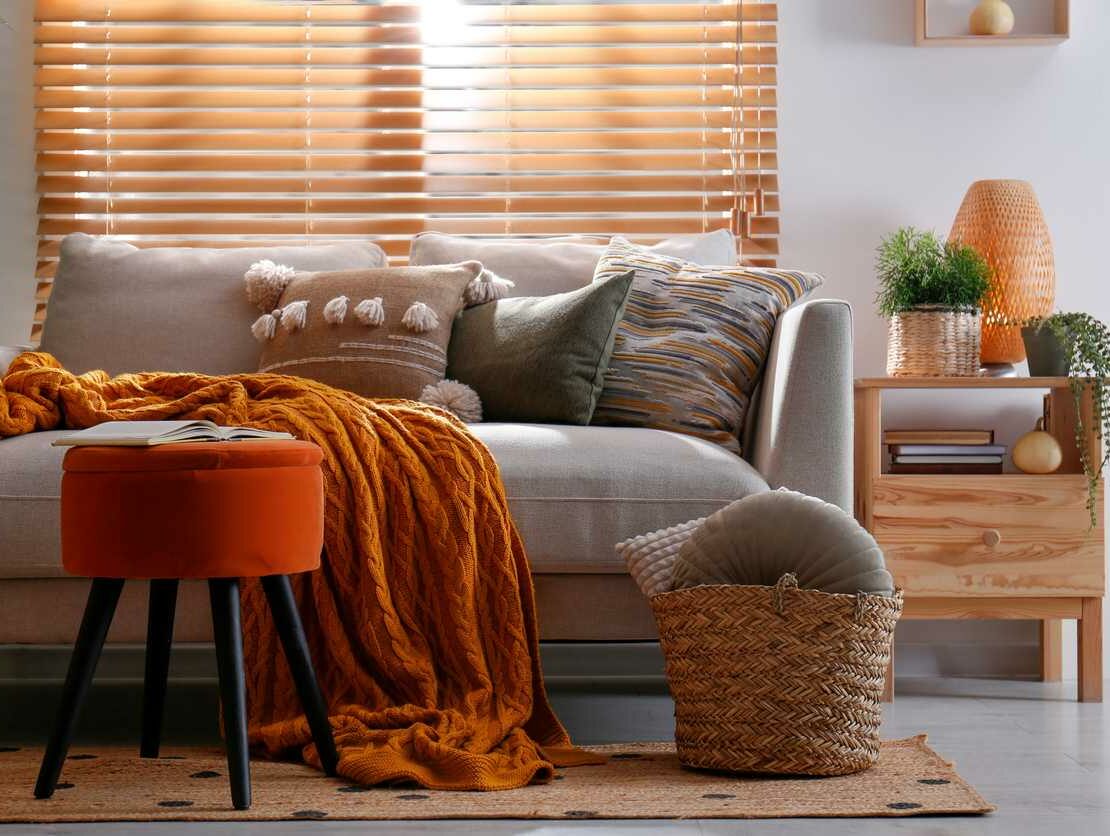 A living room is decorated for fall with cozy orange and yellow decor