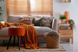 A living room is decorated for fall with cozy orange and yellow decor
