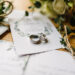 Stylish rings, flowers on wooden table background. Letters from the bride and groom.