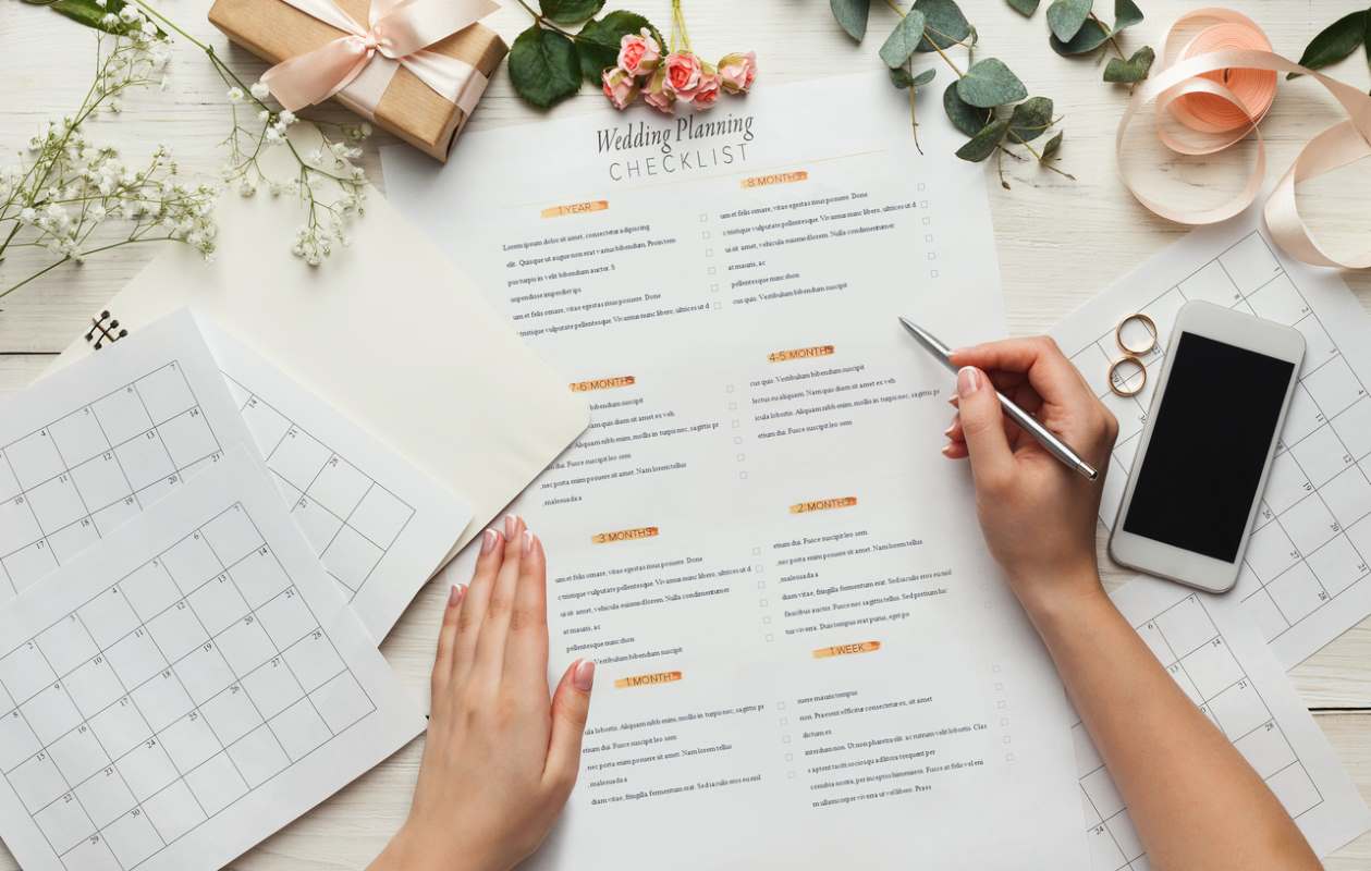 A top-view of a bride planning the wedding checklist.