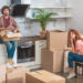 A man and woman unpacking boxes in their kitchen.