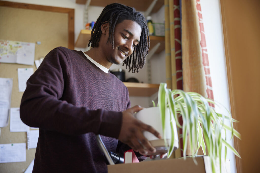 A first-year college student unpacking in his dorm room.