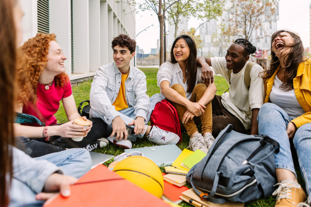 A group of college classmates getting to know one another while sitting outside.