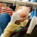 A man grabs a yellow shirt on a hanger in his closet