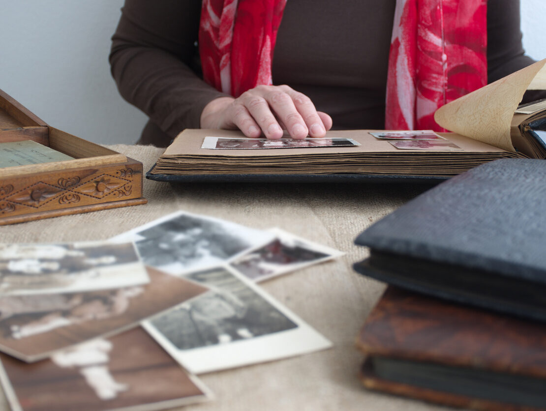 A woman browses through old photos in a family album.