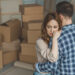 A man and woman hugging while packing up the belongings of a passed loved one.