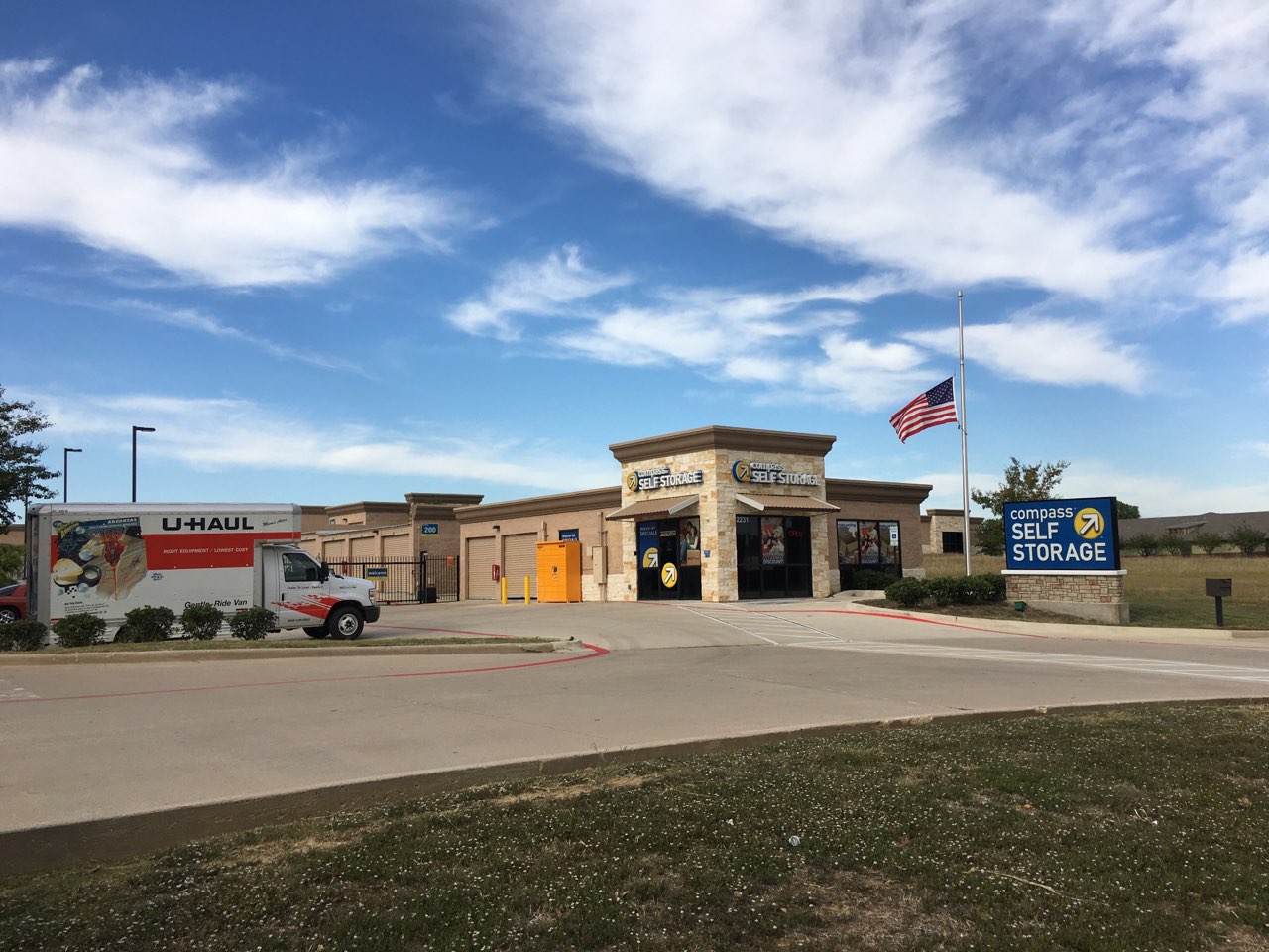 Exterior of Compass Self Storage with parking in front of the building.