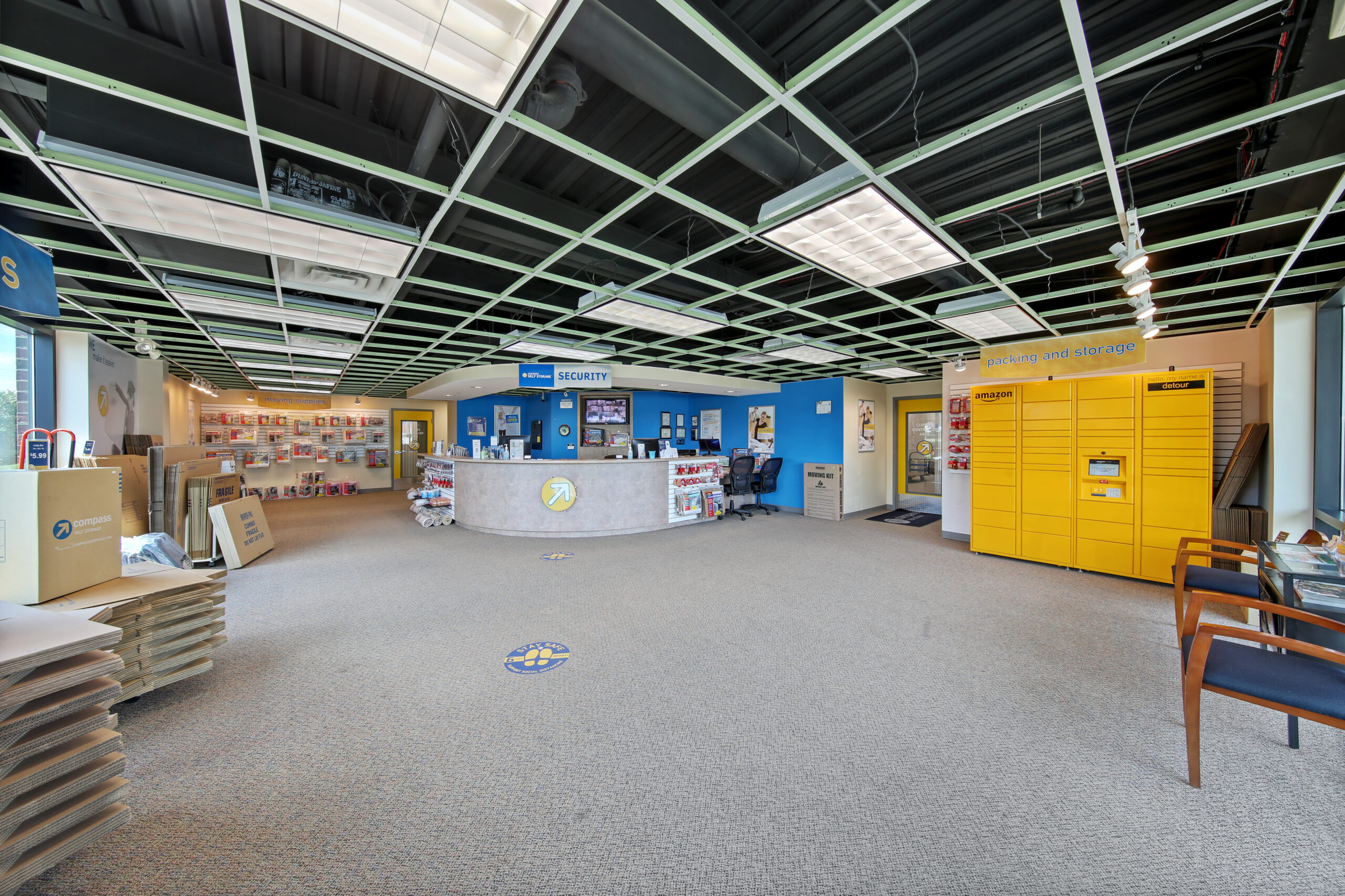 Large front office with an Amazon pickup box and storage supplies.