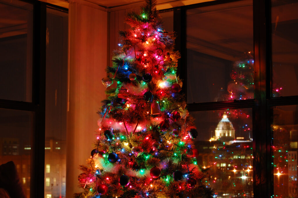 A colorfully lit Christmas tree glowing softly in the corner of a living room.