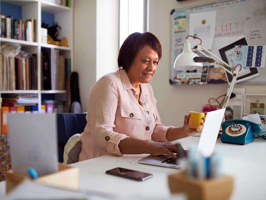 A smiling woman in her home office.