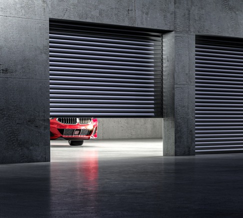 A red car inside an enclosed, drive-up storage unit.