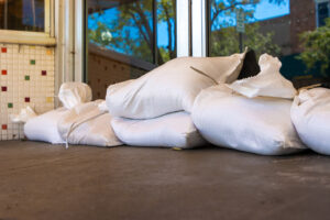 A business with sandbags in front of its doors in preparation for a hurricane.