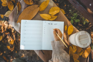 A woman writing down a to-do list as she prepares for the fall.