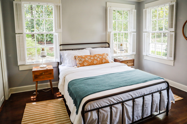 A queen bed in a guest room for short-term rentals.