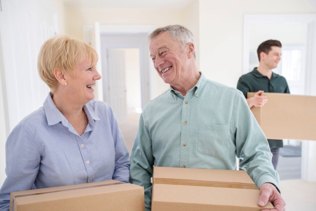 Two empty nesters moving boxes into their new home.